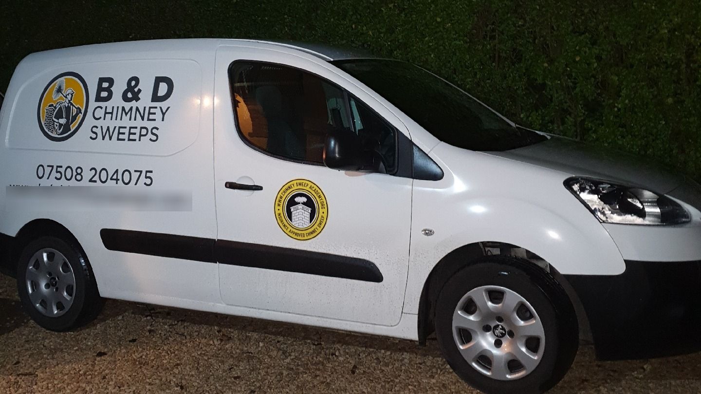 The white B & D Chimney Sweeps van with the roundel logo and phone number