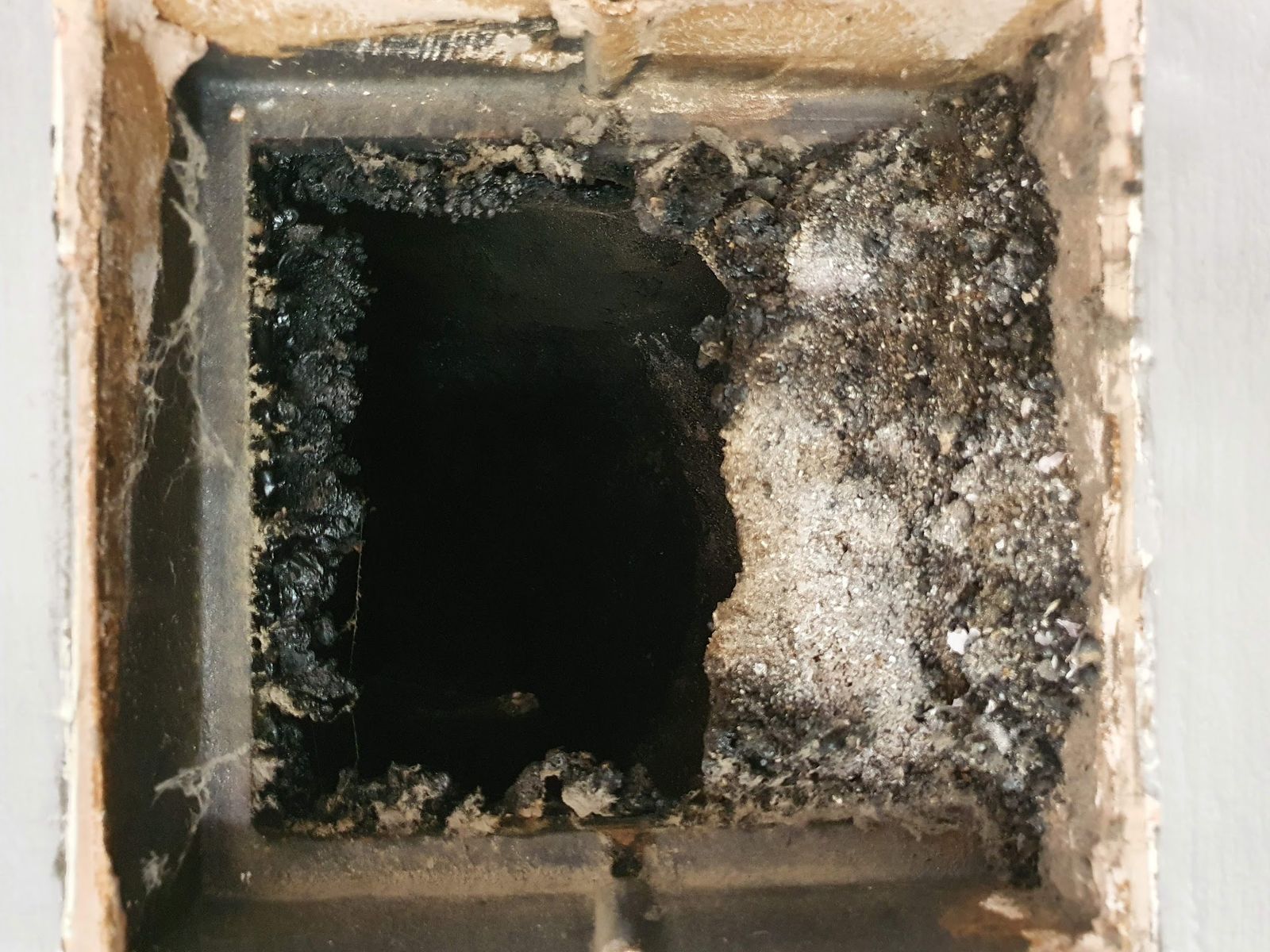 Looking up into a flue lined with soot and tar