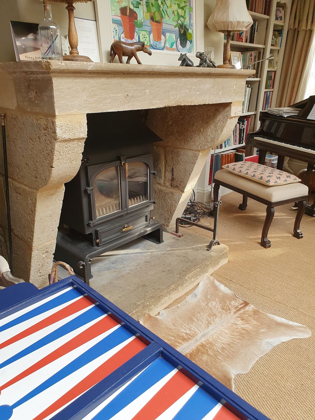 A stove in a stone fireplace in a book lined sitting room