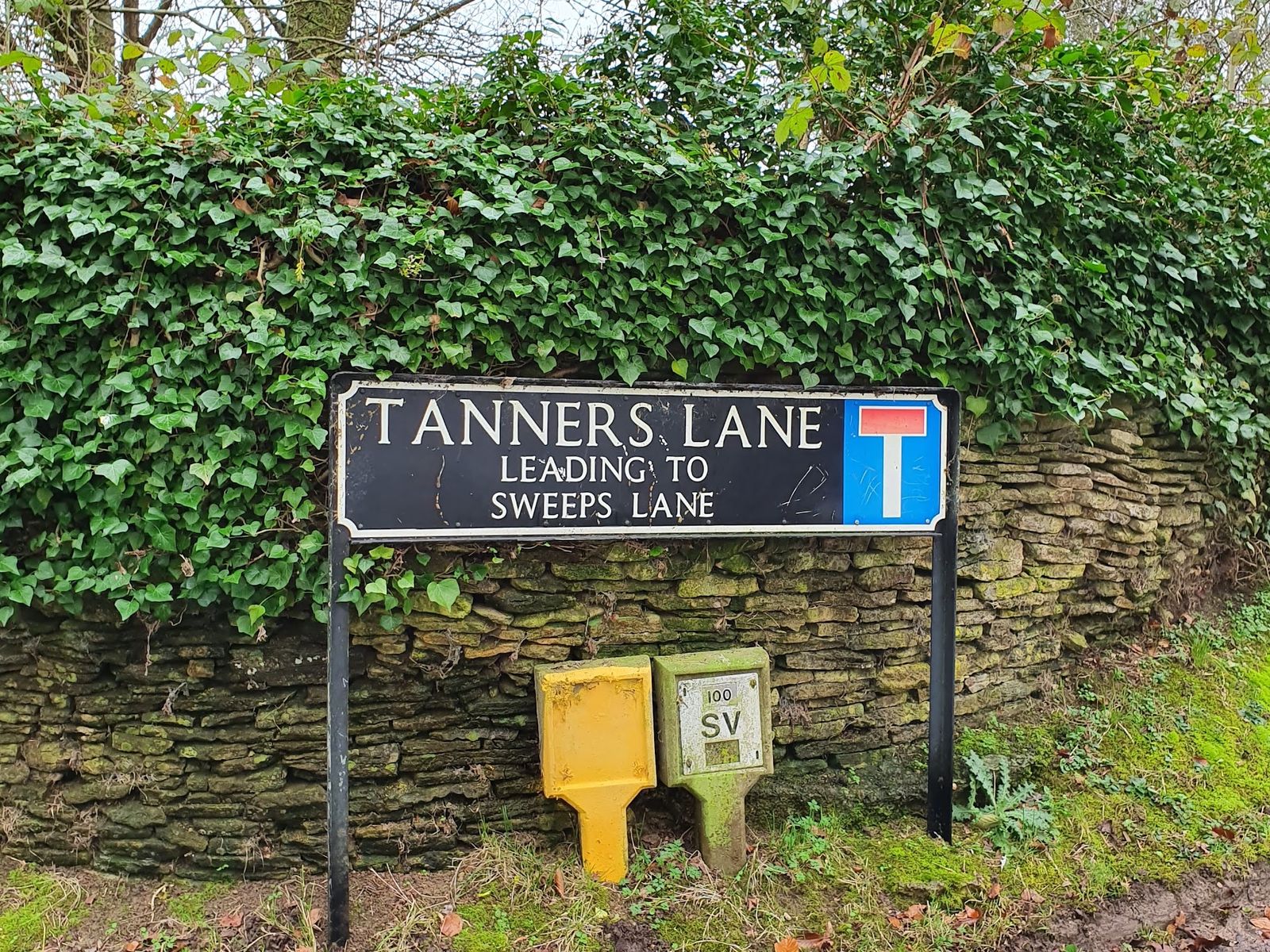 A street sign reading Tanners Lane, leading to Sweeps Lane