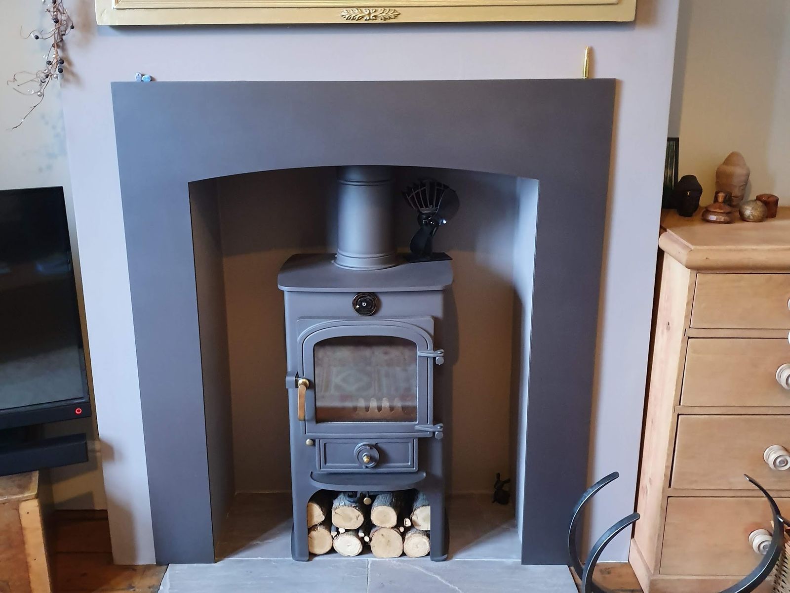 A small Clearview 400p with logs stacked below, in a grey surround