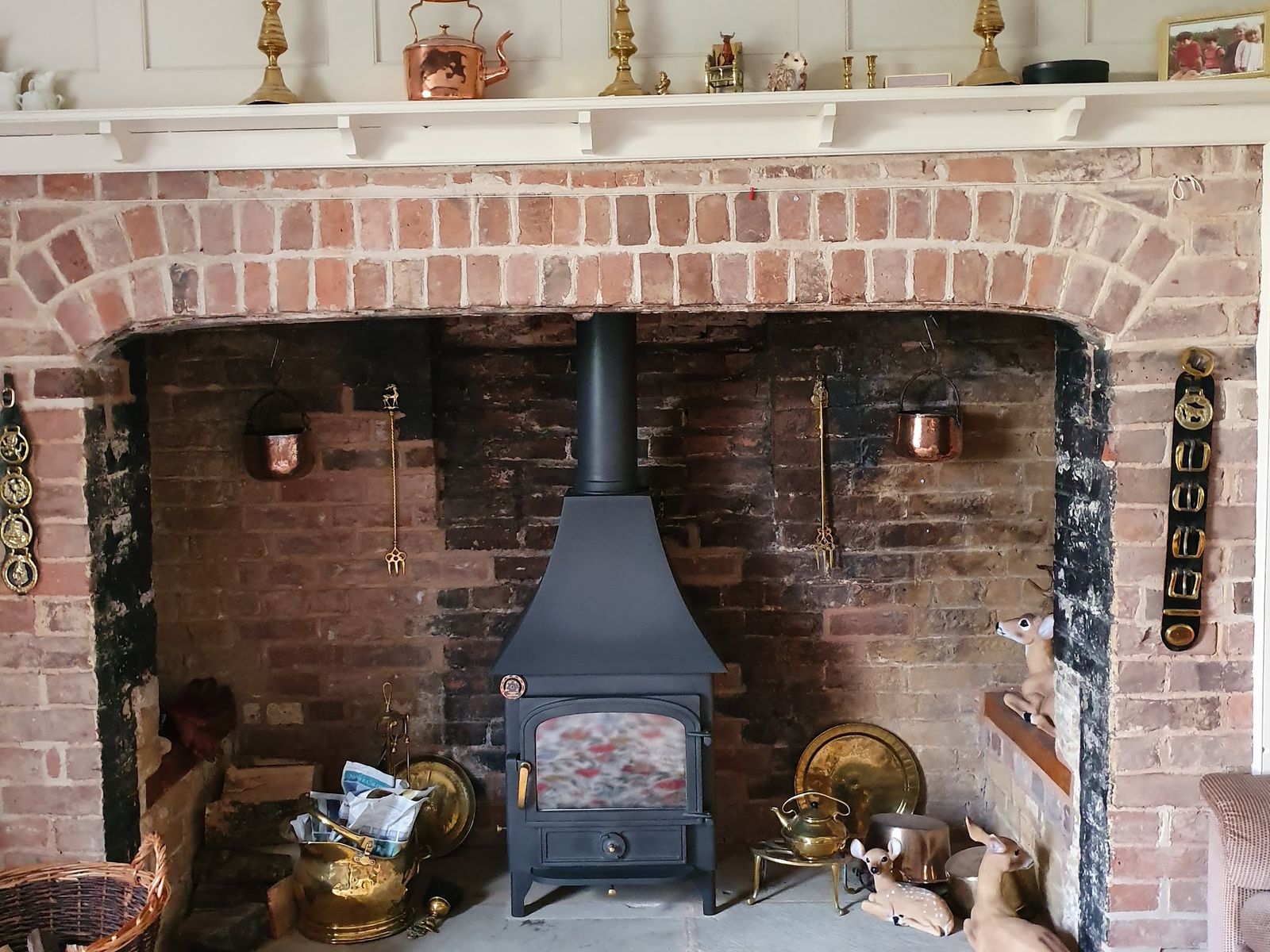 A Clearview Vision 500 in a large brick inglenook with brass ornaments