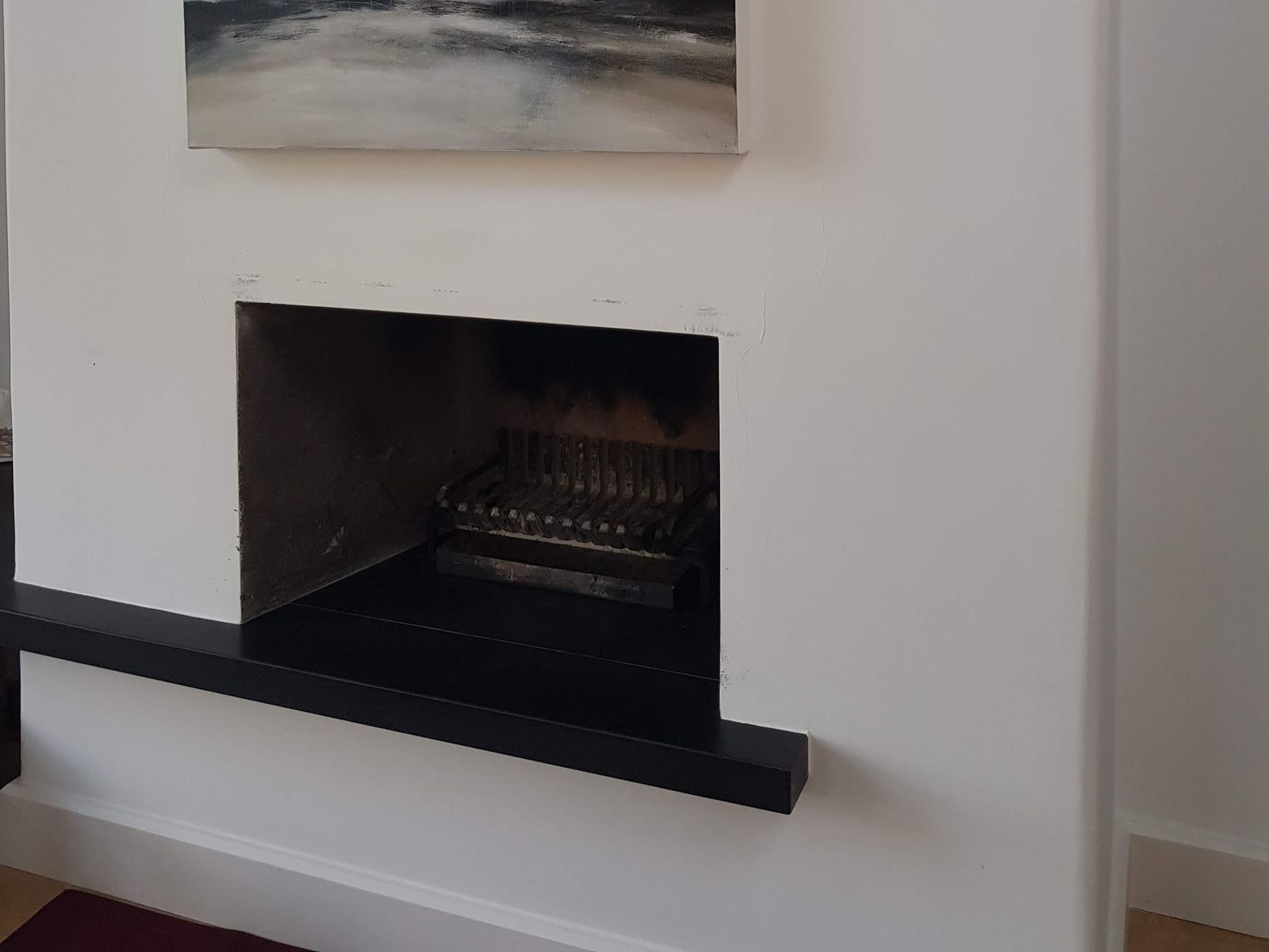 A clean open fire with a black slate hearth