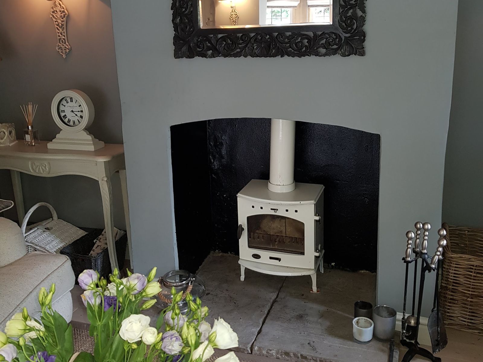 A cream enamel Carron stove in a grey painted fireplace
