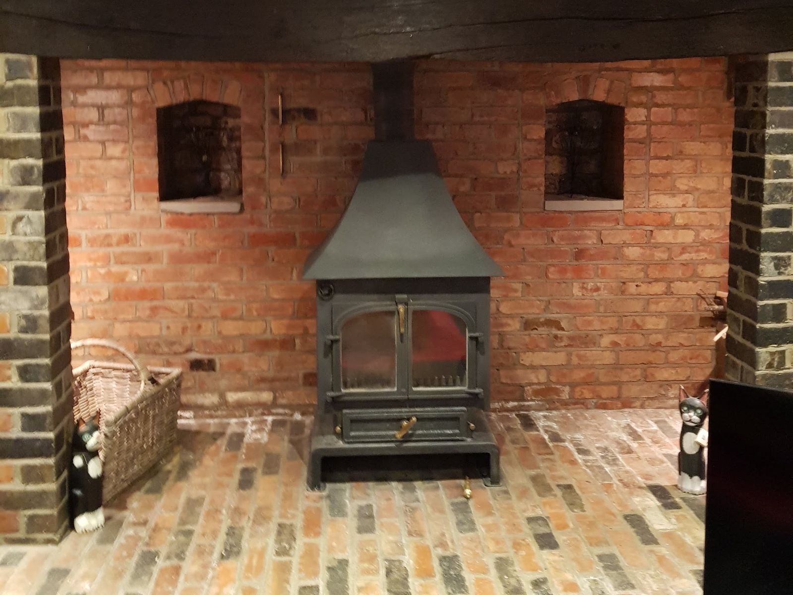 A Clearview 750 high canopy stove in a red brick fireplace